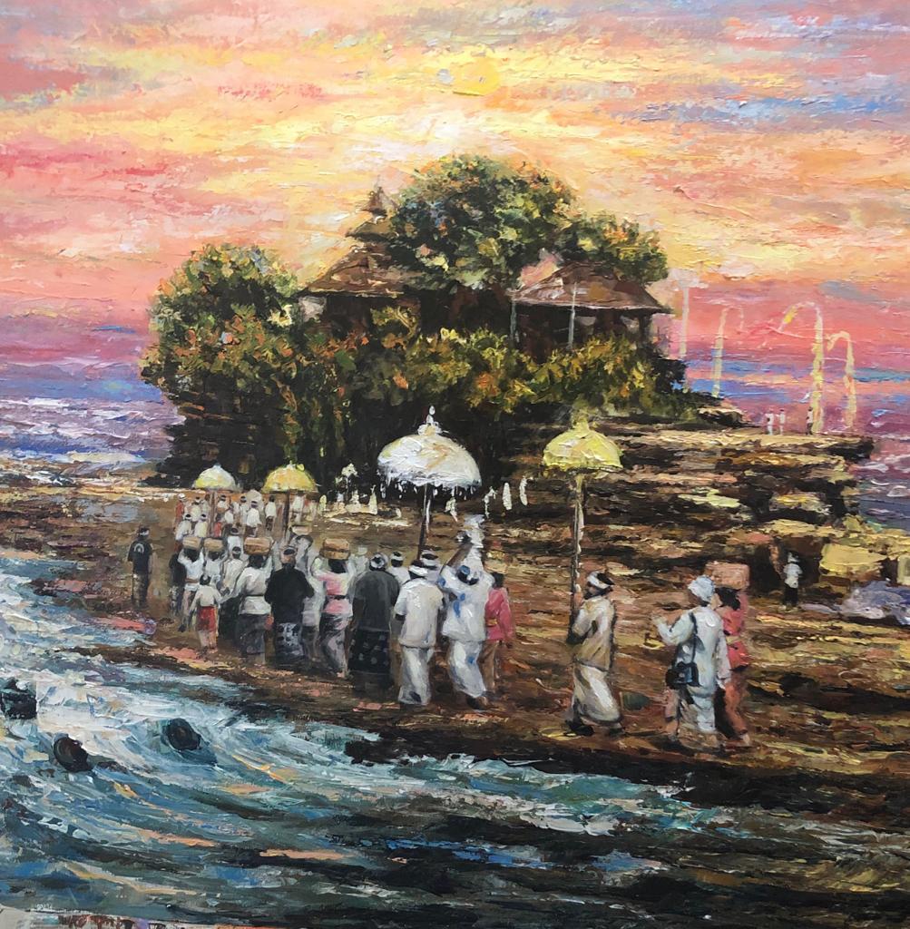 Balinese ceremonial procession beside Tanah Lot sea temple at sunset